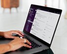Hände tippen auf einem Laptop mit geöffneter Chat-Anwendung