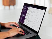 Hände tippen auf einem Laptop mit geöffneter Chat-Anwendung