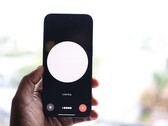 Hand hält Smartphone mit Sprachassistent-Oberfläche auf dem Bildschirm