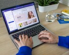 Hände tippen auf einem Laptop, auf dem Bildschirm ein Online-Shop.