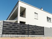 Ein Blick auf die bereits montierten PV-Streifen. Sie werden wie handelsübliche Sichtschutzstreifen in den Doppelstabmattenzaun gefädelt. (Bildquelle: Sunbooster via OTS)