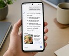 Hand hält ein Smartphone, auf dem unter einer KI-Antwort eine als gesponsert markierte Anzeige steht