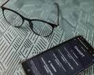 Smartphone mit geöffneter ChatGPT-App neben einer Brille auf einer gemusterten Fläche