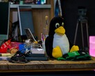 Plüschfigur des Linux-Pinguins Tux auf einem Werkstatttisch
