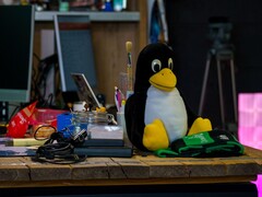 Plüschfigur des Linux-Pinguins Tux auf einem Werkstatttisch