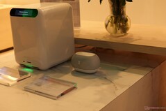 Zu sehen sind eine HomeAgent-Basisstation und der smarte Lautsprecher