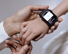 Erwachsene Hand richtet eine Smartwatch am Handgelenk eines Kindes ein