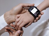 Erwachsene Hand richtet eine Smartwatch am Handgelenk eines Kindes ein