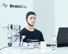 Ein Nutzer steuert mit BrainCos Technologie allein durch Gedanken eine Roboterhand, die einen Apfel greift