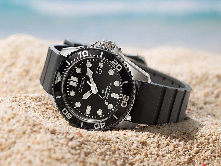 Eine Citizen Promaster Marine BN0266-07E mit schwarzem Zifferblatt, schwarzer Lünette und schwarzem Armband, die auf Sand liegt.
