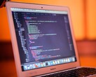 Aufgeklapptes MacBook zeigt Programmcode auf dem Bildschirm