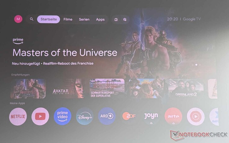 Google TV Oberfläche des Etoe Dolphin 2 (leicht abgedunkelter Raum mit Fenster rechts, Hochkontrastleinwand)