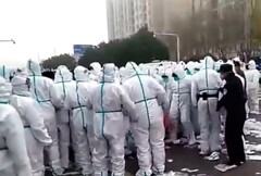 Weiß gekleidete Sicherheitskräfte treten einen Arbeiter, der schon am Boden liegt. (Bild: @StephenMcDonell, Twitter)