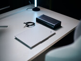 Ein geschlossener weißer Lenovo ThinkPad Laptop liegt neben einer schwarzen Aorus RTX 5060 Ti AI Box eGPU und einem eingerollten Thunderbolt-Kabel auf einem hellen Schreibtisch.