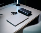 Ein geschlossener weißer Lenovo ThinkPad Laptop liegt neben einer schwarzen Aorus RTX 5060 Ti AI Box eGPU und einem eingerollten Thunderbolt-Kabel auf einem hellen Schreibtisch.