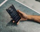 Hand hält ein Smartphone mit geöffneter ChatGPT-App über einem gemusterten Tisch