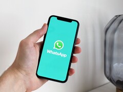 Hand hält ein Smartphone mit geöffneter WhatsApp-App