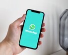 Hand hält ein Smartphone mit geöffneter WhatsApp-App