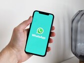 Hand hält ein Smartphone mit geöffneter WhatsApp-App