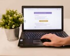 Laptop auf einem Schreibtisch mit geöffnetem E-Mail-Postfach, daneben eine Zimmerpflanze.