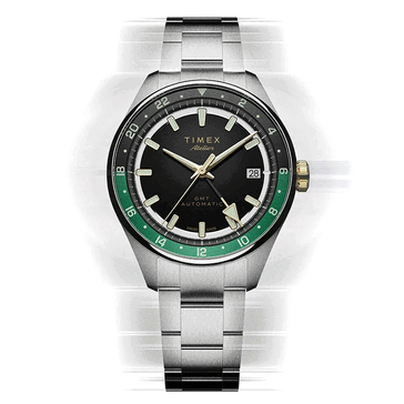 Timex Atelier GMT Première M1a mit schwarzem Zifferblatt, grünem GMT-Ring und Edelstahlarmband.