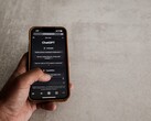 Hand hält ein Smartphone mit geöffneter ChatGPT-Oberfläche über einer grauen Steinfläche