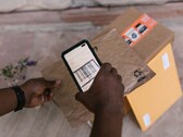 Hand hält ein Smartphone über ein Paket und scannt den Barcode