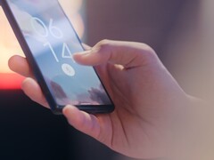 Hand hält ein Smartphone und entsperrt es per Fingerabdrucksensor auf dem Sperrbildschirm.