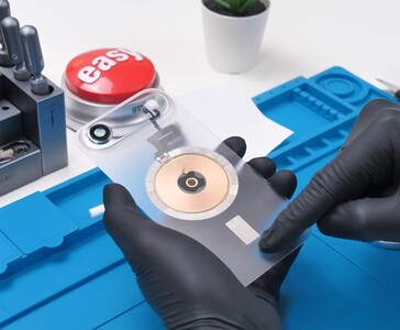 Transparentes iPhone Air-Rückseitenglas mit sichtbarer kupferner Ladespule und Kameramodul während des Modding-Prozesses. (Bildquelle: Phone Repair Guru via YouTube)