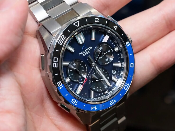 Nahaufnahme des blauen Zifferblatts der Casio Oceanus OCW-P3000 mit Stadtcodes, Hilfszifferblättern, leuchtenden Stundenindizes und breiten Zeigern.