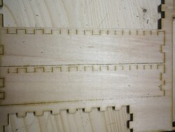 Nicht vollständig zerteiltes Sperrholz neben perfekt ausgeschnittenen Bereichen
