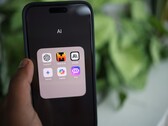 Hand hält ein Smartphone mit einem Ordner voller KI-Apps auf dem Bildschirm