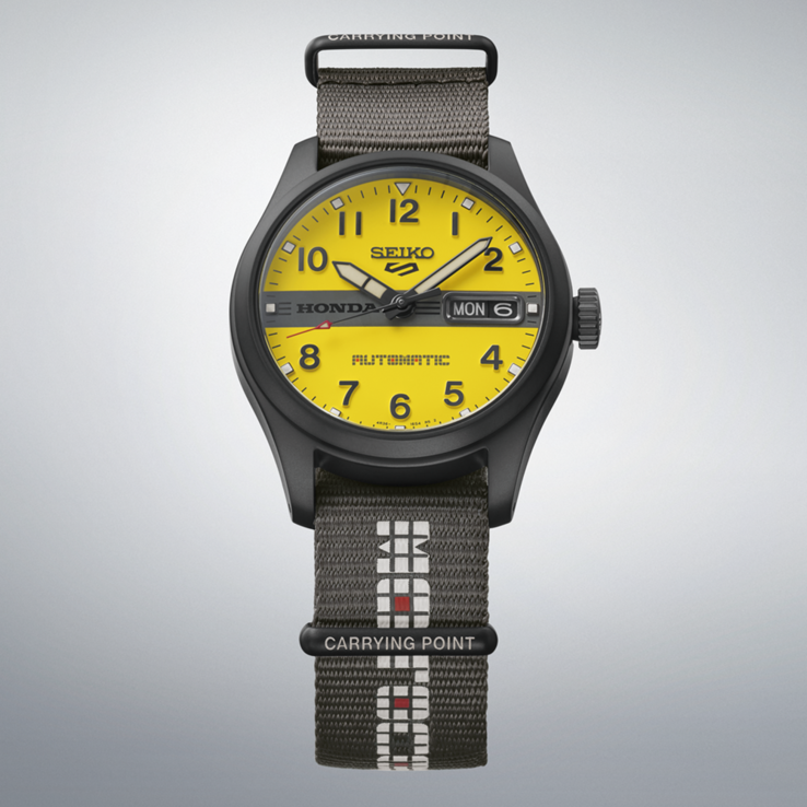 Vorderansicht der Seiko 5 Sports Field x Honda Motocompo Limited Edition mit gelbem Zifferblatt, zentral platziertem schwarzen Honda-Logo und grauem Nylonarmband