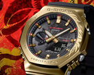 Die Casio G-Shock GBM-2100CX-9AJR mit gravierter goldfarbener Lünette, abgebildet vor einem stilisierten roten Hintergrund. (Bildquelle: Casio)