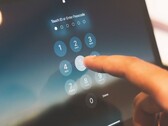 Finger tippt eine PIN auf einem Ziffernfeld am Bildschirm ein