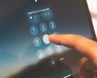 Finger tippt eine PIN auf einem Ziffernfeld am Bildschirm ein