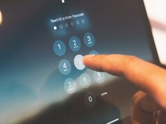 Finger tippt eine PIN auf einem Ziffernfeld am Bildschirm ein