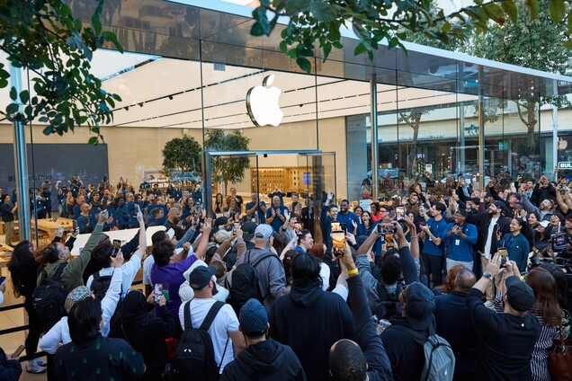 Kunden feiern mit John Ternus und Deirdre O'Brien im Apple Domain Northside den Verkaufsstart des iPhone Duo