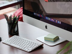iMac auf einem Schreibtisch mit sichtbarem macOS-Dock, davor eine Apple-Tastatur