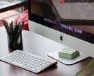 iMac auf einem Schreibtisch mit sichtbarem macOS-Dock, davor eine Apple-Tastatur