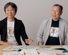 Shigeru Miyamoto und Takashi Tezuka mit T-Shirts zum 30. Jubiläum von Super Mario Bros.