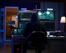 Eine vermummte Gestalt führt an einem Multi-Screen-Setup einen Cyberangriff durch