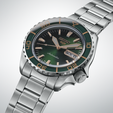 Nahaufnahme der Seiko 5 Sports SKX HDB005 mit dunkelgrünem Zifferblatt, roségoldfarbenen Zeigern und Indizes sowie passender grüner Lünette mit goldfarbenen Markierungen
