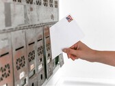Hand steckt einen Briefumschlag in eine Reihe von Briefkästen