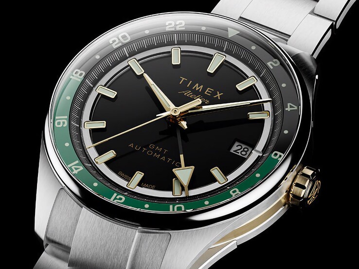 Schrägansicht der Timex Atelier GMT Première M1a mit schwarzem Zifferblatt, grünem GMT-Ring, goldfarbener Krone und Edelstahlarmband.