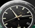 Nahaufnahme des schwarzen Zifferblatts der Timex Atelier GMT Première M1a mit goldfarbenen Zeigern, Leuchtindizes, einem Datumsfenster und einem schwarz-grünen 24-Stunden-GMT-Ring.