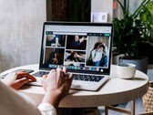 Person tippt an einem Laptop im Café, auf dem Bildschirm ein Browserfenster mit Tableiste und Adresszeile