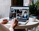 Person tippt an einem Laptop im Café, auf dem Bildschirm ein Browserfenster mit Tableiste und Adresszeile