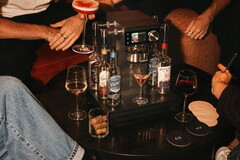 Menschen sitzen um den Cocktail-Automaten herum