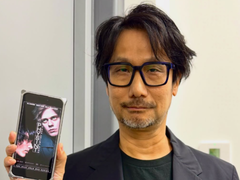 Hideo Kojima zeigt ein Poster zu Physint auf seinem Smartphone